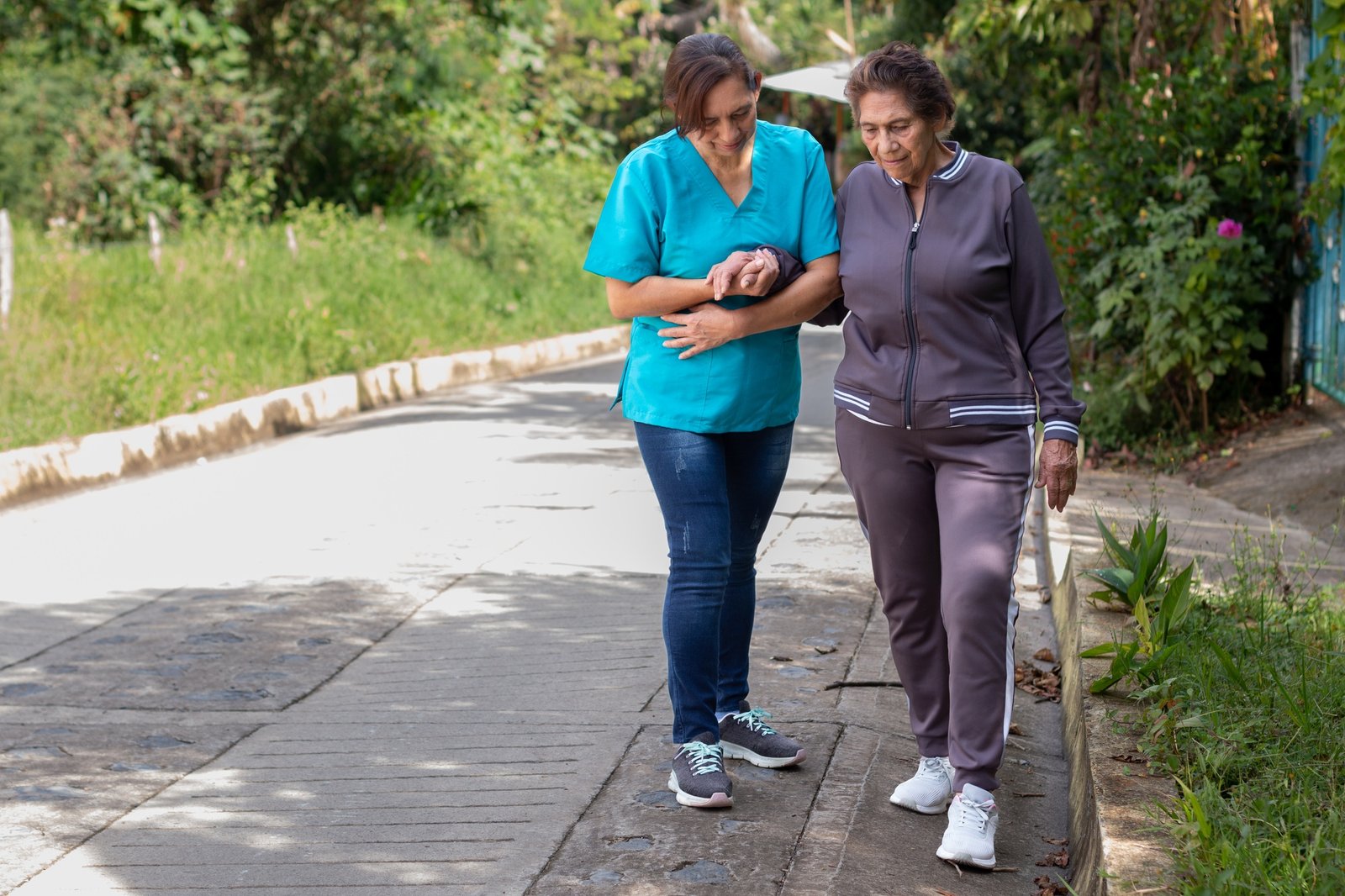 Nurse assisting an elderly woman with walking difficulties in her daily routine. Active aging.